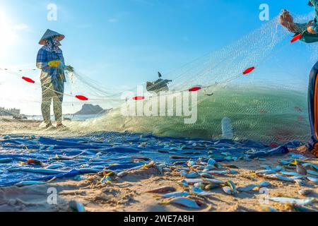 Fischmarkt Session Seeszene Menschen versammelten sich im Korb Fischverkauf, anstrengende Ruderfischer brachten an Land Fischerdorf in Phan Thiet Stockfoto