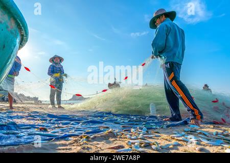 Fischmarkt Session Seeszene Menschen versammelten sich im Korb Fischverkauf, anstrengende Ruderfischer brachten an Land Fischerdorf in Phan Thiet Stockfoto