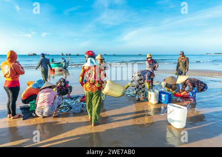Fischmarkt Session Seeszene Menschen versammelten sich im Korb Fischverkauf, anstrengende Ruderfischer brachten an Land Fischerdorf in Phan Thiet Stockfoto