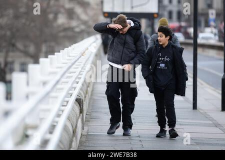 London, Großbritannien. Januar 2024. Pendler überqueren die Waterloo Bridge in London. Während des Sturms Isha wurden Flüge und Züge gestrichen, und es bestehen weiterhin Warnungen zur Lebensgefahr mit der Gefahr möglicher Tornados in Teilen des Landes. Quelle: SOPA Images Limited/Alamy Live News Stockfoto