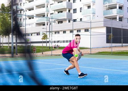 Mann spielt Pickleball-Spiel, schlägt Pickleball-Ball mit Paddel, Outdoor-Sport Freizeitaktivitäten Stockfoto