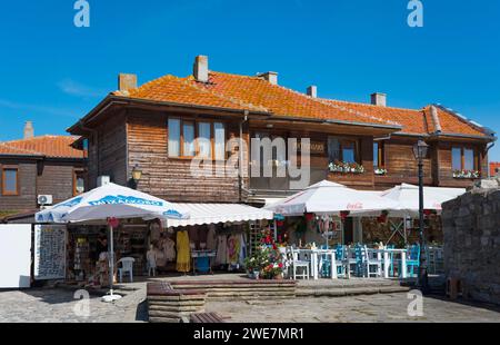 Restaurant mit Open-Air-Tischen neben Souvenirläden in einem traditionellen Holzgebäude, Schwarzes Meer, Nesebar, Nessebar, Burgas, Bulgarien Stockfoto