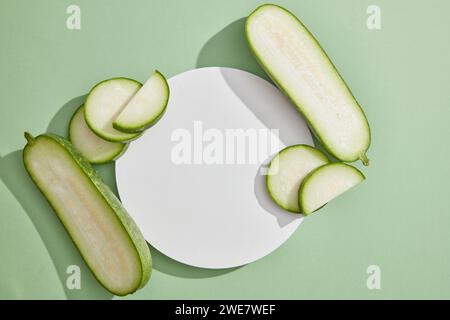 Weißes Podium in runder Form, dekoriert mit Wintermelone. Leerraum auf dem Podium für die Produktpräsentation der Wintermelone (Benincasa hispid Stockfoto