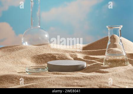 Laborkonzept am Strandsand mit rundem Podium in grauer Farbe. Natürliche Hautpflege Beauty Produktkonzept mit blauem Himmel Hintergrund Stockfoto