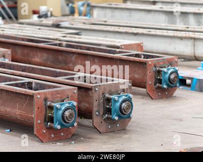 Schneckenförderer mit Kugellagern bei der Herstellung in einer Industriewerkstatt. Geringe Schärfentiefe mit den beiden nächstgelegenen Förderern im Fokus. Stockfoto