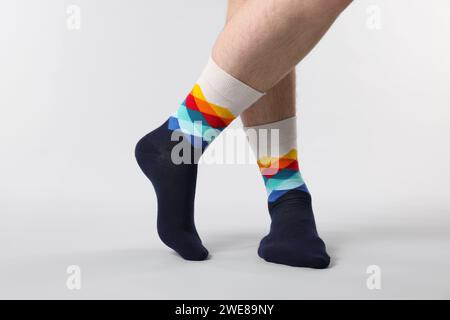 Mann in stilvollen bunten Socken auf weißem Hintergrund, Großaufnahme Stockfoto