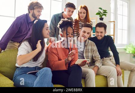 Gruppen von Freunden nutzen gemeinsam das Mobiltelefon, um Fotos, Videos oder Internetsuche anzusehen. Stockfoto