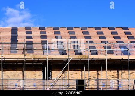 Fliesen gestapelt und bereit für die Verlegung auf dem Dach eines im Bau befindlichen Hauses Stockfoto