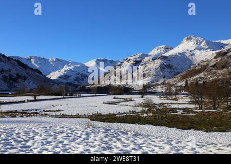Langdale Valley, Unberührter Winterblick. Wunderschöner blauer wolkenloser Himmel und frischer Schnee über dem Talboden und den Bergen. Stockfoto