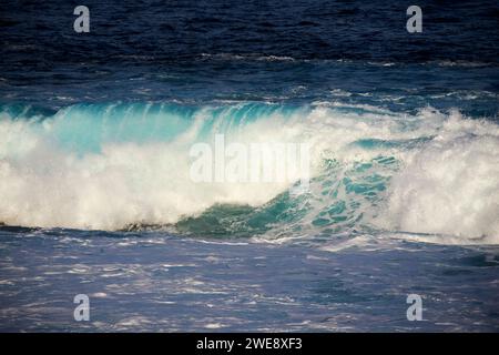 Blaue Meereswellen brechen über die flache felsige Küste an der atlantikküste der lanzarote kanarischen Inseln spanien Stockfoto