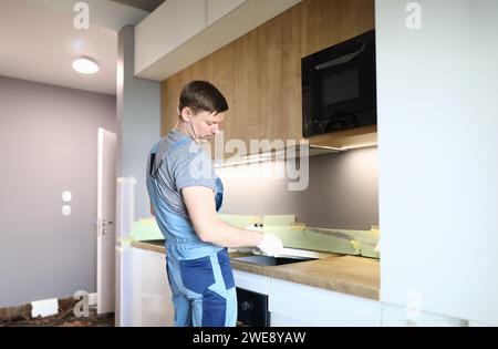 Mann elektrische Reparaturen Küche Oberfläche Wohnung Stockfoto