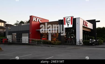 Äußere des KFC Fast Food Restaurants im Vorort Melbourne, mit beleuchtetem Colonel Sanders Logo, rund um den Sonnenuntergang Stockfoto