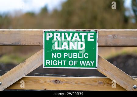 Privates Land, kein öffentliches Wegschild in grün und weiß. Schild an einem Farmtor befestigt. Stockfoto