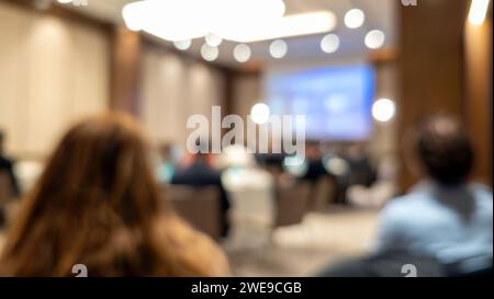 Gruppe von Geschäftsleuten, die an einem Meeting teilgenommen haben und eine Präsentation im Büro anschauen. Verschwommenes Bild Stockfoto