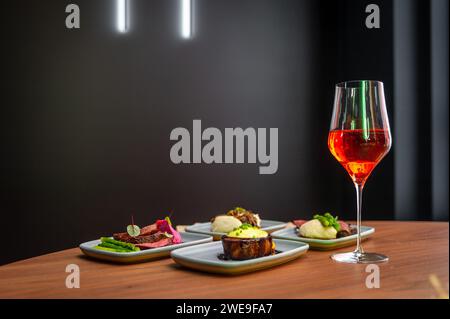Eine Auswahl an Gerichten auf einem Tisch in einem Restaurant mit einem Glas Wein. Stockfoto