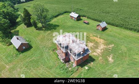 Blick aus der Vogelperspektive auf verlassene ländliche Villa mit üppiger Umgebung Stockfoto