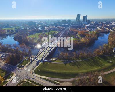 Aerial Autumn Urban Park with Arched Bridge and City Skyline Stockfoto