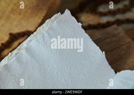 Abgerissene weiße Papierstruktur auf warmbraunem Hintergrund Stockfoto