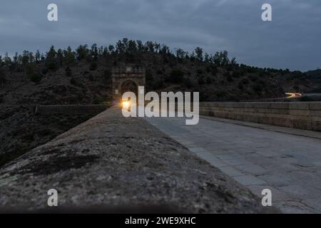 Fotografía nocturna en el puente romano de Alcántara. Luz de un coche que está cruzando el puente, Cáceres, España Stockfoto