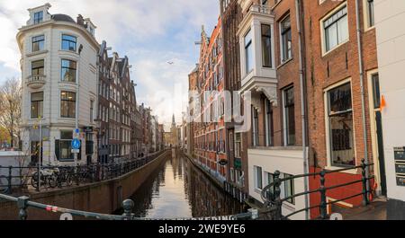 Amsterdam, Niederlande - 7. Dezember 2022: Blick durch die historischen Häuser und Flüsse Amsterdams zur Kirche Oude Kerk *** Blick durch die historischen Häuser und Flüsse von Amsterdam auf die Oude Kerk Kirche Stockfoto