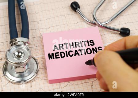 Medizinisches Konzept. Auf den Kardiogrammen befinden sich ein Stethoskop und ein Aufkleber mit der Aufschrift - Arthritis-Medikamente Stockfoto