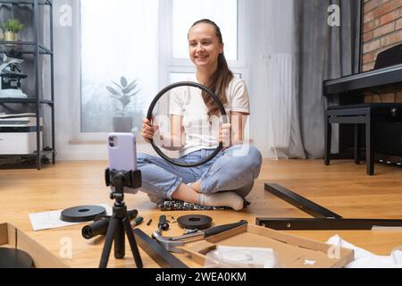 Ein Mädchen zeigt Möbeldetails per Videolink mit der Kamera ihres Smartphones Stockfoto