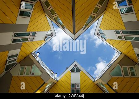 Blick nach oben auf den ikonischen gelben Würfel Kijk-Kubus von Piet Blom in Rotterdam vor einem blauen Himmel mit Wolken Stockfoto