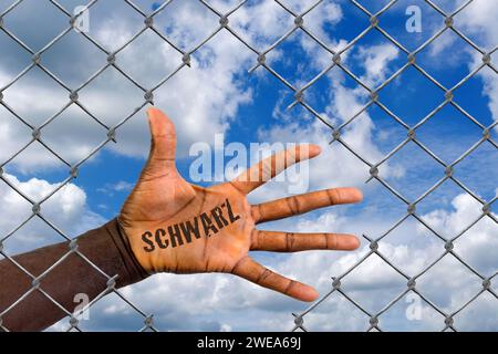 Die Hand eines Ausländers hinter einem Maschendrahtzaun, Loch, Schlupfloch, Hilfe, Flüchtling, Asyl, Migrant, Migration, Ausländer, Schwarz, Afrikaner Stockfoto