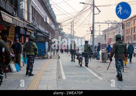 Srinagar, Indien. Januar 2024. Indische paramilitärische Truppen patrouillieren zusammen mit einem Schnüffelhund vor dem Indischen Tag der Republik durch die Straßen. Die indischen Behörden im Kaschmir-Tal haben die Sicherheitsmaßnahmen verstärkt, um störende Aktivitäten im Vorfeld der Feierlichkeiten zum Tag der Republik am 26. Januar zu unterbinden. Mit Drohnen und hochauflösenden CCTV-Kameras, die Bewegungen in Echtzeit überwachen, wurden die Fahrzeugfetzen und Inspektionen verstärkt. Der Tag der Republik feiert den Jahrestag der Verabschiedung der indischen Verfassung am 26. Januar 1950. Quelle: SOPA Images Limited/Alamy Live News Stockfoto