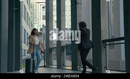 Indische Geschäftsfrau Ankunft in der Stadt mit Reisetasche Gepäckkoffer Arabische Geschäftsmann Treffen Umarmung weibliche Partner Geschäftstreffen am Flughafen Stockfoto