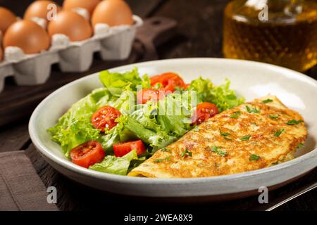 Omelette mit Käse, Salat und Tomatensalat. Stockfoto