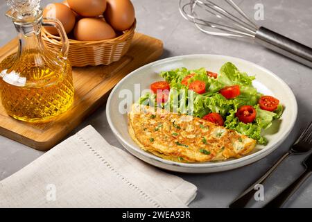 Omelette mit Käse, Salat und Tomatensalat. Stockfoto