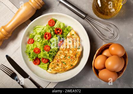 Omelette mit Käse, Salat und Tomatensalat. Stockfoto