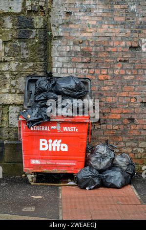 Ein überlaufender Biffa Abfalleimer auf Rädern, gefüllt mit allgemeinen gewerblichen Abfällen in schwarzen Müllsäcken, Glasgow, Schottland, Großbritannien, Europa Stockfoto