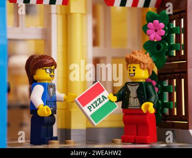 Tambov, Russische Föderation - 21. Januar 2024 Ein Lego-Liefermann gibt der Lego-Frau im Freien eine Pizzaschachtel Stockfoto
