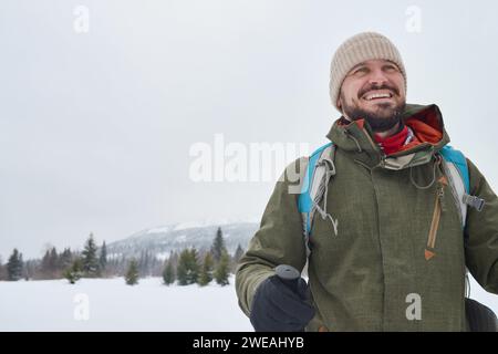 Aufgeregt glücklicher Bärenbergsteiger allein, der seine unglaubliche Reise im Winter genießt Stockfoto