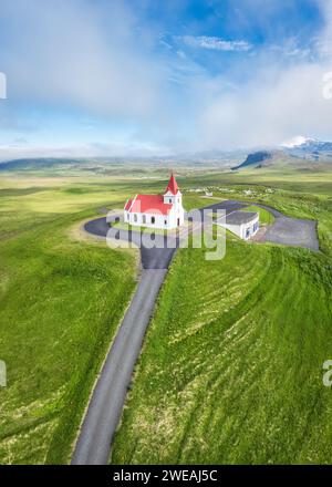 Blick aus der Vogelperspektive auf die wunderschöne heilige Ingjaldsholskirkja Kirche auf einem Hügel zwischen der Wiese und im Sommer Nebel auf der Halbinsel Snaefellsnes, Island Stockfoto