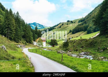 Ländliche Szene des rustikalen Dorfes im Tal während des Wanderweges Seealpsee im Sommer in Appenzell, Schweiz Stockfoto