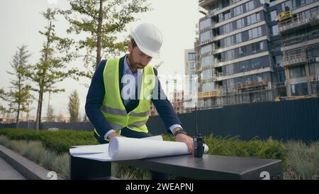 Nachdenklicher männlicher Architekt nachdenklich umschauen denken prüfen städtische Infrastruktur Herstellung Blueprint Denken Arbeiter Reparaturmann Mann in Stadt lösen Stockfoto