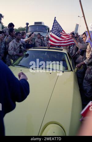 Erster Golfkrieg: 1. März 1991 Kuwaitis wehte die amerikanische Flagge auf den Straßen von Kuwait City, nachdem sie durch Koalitionstruppen befreit wurden. Stockfoto