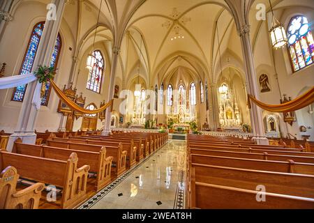Elegantes Kircheninnere mit Buntglas und Bänken, Blick auf den Gang auf Augenhöhe Stockfoto