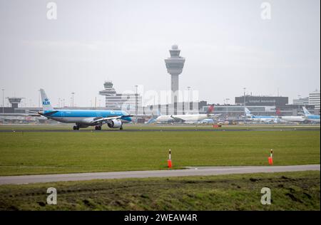 Amsterdam Niederlande 24. Januar 2024 Flugzeuge landen am Flughafen Schiphol. KLM Embraer E195-E2 PH-NXC mit Anschlussklemmen, Steuerturm und Piers in der Entfernung. niederländisch, nl, vliegtuig, flugzeug, aankomst, Ankunft, Flugzeug, Buitenveldertbaan, Stockfoto