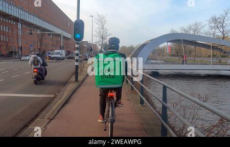 Amsterdam Niederlande 24. Januar 2024 Fahrradfahrer mit Nahrungsmitteln fahren zu ihrem Ziel. Uber isst Bestelling, Gig, Economy, Ride, Rider, fietser, Mahlzeit, maaltijd, Bestellung, Stockfoto