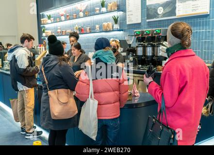 Kunden und potenzielle Kunden feiern die feierliche Eröffnung einer Filiale des Capital One Cafe am Herald Square in New York am Samstag, den 20. Januar 2024. Das einladende Café serviert Speisen und Getränke und dient als Co-Working-Bereich, egal ob Sie Kunde sind oder nicht. (© Richard B. Levine) Stockfoto