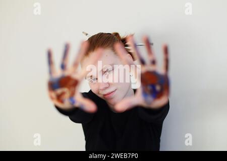 Das Mädchen streckte ihre Hände nach vorne, mit Farben befleckt Stockfoto