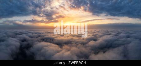 Wunderschöner dramatischer Sonnenuntergang Himmel über flauschigen Wolken am frühen Morgen. Drohnenansicht. Stockfoto