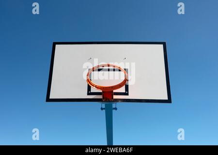 Basketballkorb und Rückenbrett vor einem klaren blauen Himmel Stockfoto