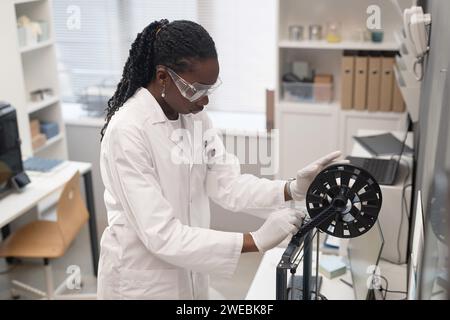 Frau Ingenieurin, die den 3D-Drucker einrichtet Stockfoto