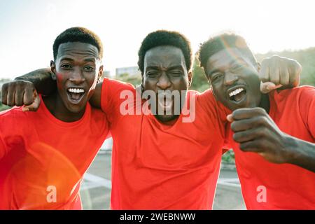 Afrikanische Fußballfans feiern das Spiel im Crowd-Stadion. Die roten Fußballfans schreien nach dem Team in der Meisterschaft Stockfoto