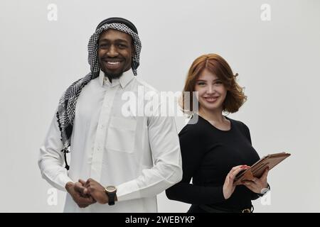 Eine arabische Unternehmerin und eine Geschäftsfrau, die Vertrauen und Einheit ausstrahlt, posieren vor einem klaren weißen Hintergrund und symbolisieren eine dynamische Partnerschaft Stockfoto
